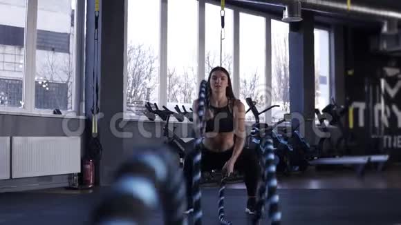 女子在健身房训练用战绳强大迷人的白种人女人在健身房用绳索进行战斗锻炼视频的预览图