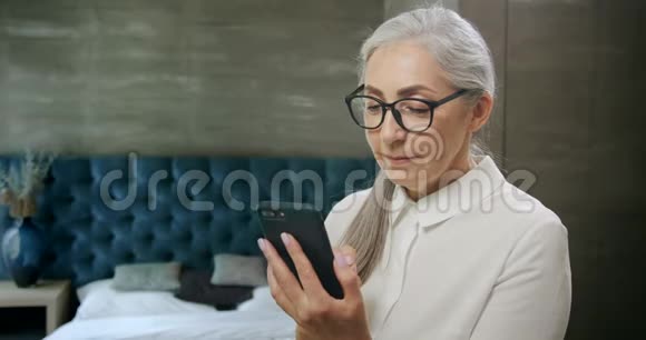老年妇女在智能手机上发短信视频的预览图