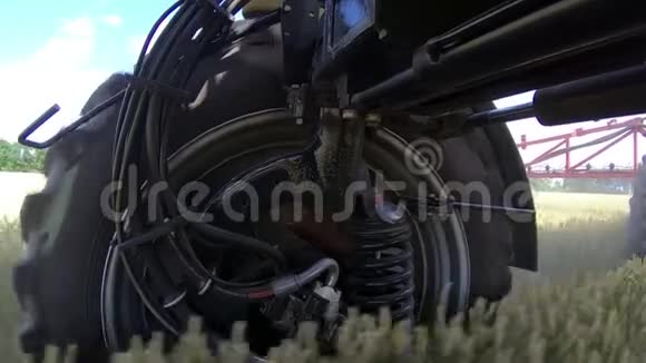 大轮子在一个自动推进的喷雾器上旋转同时穿过田野视频的预览图