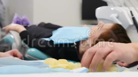 一个穿着医用长袍戴着医用手套的男性牙医剪下的框架站在他的手臂上视频的预览图