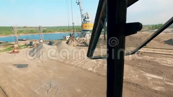 在港口作业的起重机的金属桶掉落的碎石视频的预览图