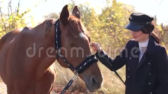 年轻的职业模特女孩与马在秋季公园摆姿势视频的预览图