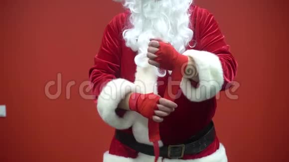 圣诞老人拳击手在红墙的背景下使用红色绷带视频的预览图