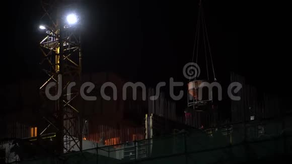 在夜间施工现场一台起重机吊起混凝土搅拌机视频的预览图