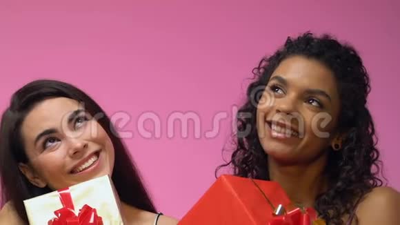 两个多民族的女人拿着礼物盒梦想着节日关门视频的预览图