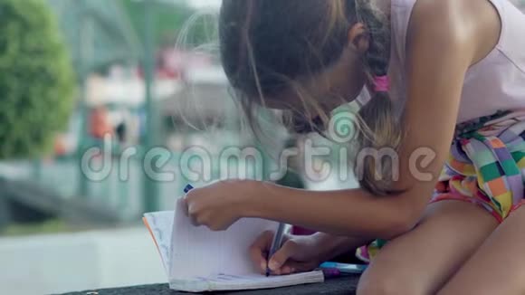 女孩写在笔记本上学习户外用品视频的预览图