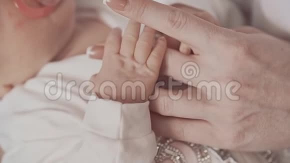 新生儿牵着妈妈手以缓慢的速度关闭家庭概念视频的预览图