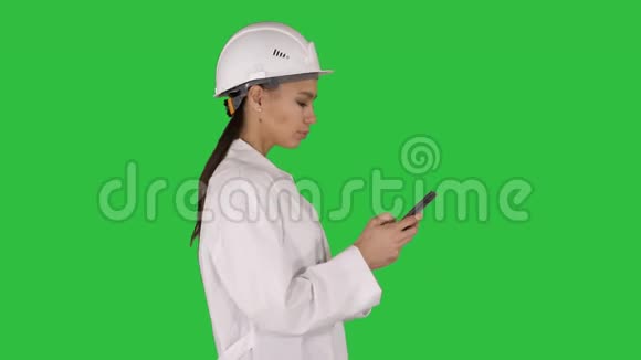工程师在绿色屏幕上行走时使用手机短信Chroma键视频的预览图