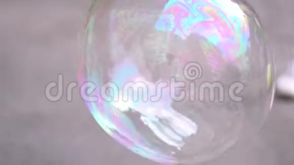 一个大的彩色肥皂泡缓慢地降落在路上视频的预览图