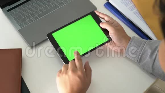 商务男士手拿平板电脑在办公室绿色桌面屏幕上的4k视频视频的预览图