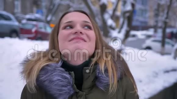 一位年轻美丽的白种人女性的特写镜头她黑发微笑着梦想着在雪地里的街道上视频的预览图