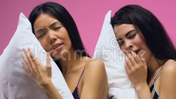 漂亮的女人穿着睡衣打哈欠睡在枕头上做着甜蜜的梦视频的预览图