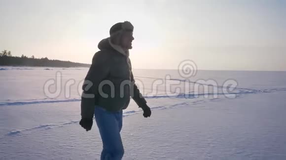 在雪域的阳光下一个快乐的人在侧面向右走着视频的预览图