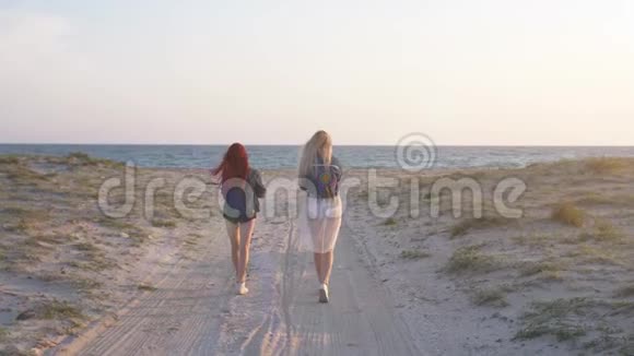 黄昏时分几个年轻的女人在沙滩上散步穿着印度式的泳装和短裤视频的预览图