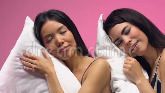 美丽的多民族妇女睡在粉红色背景的枕头上做梦视频的预览图