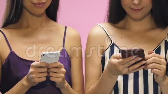 穿着睡衣微笑的女人在智能手机上发短信邀请派对视频的预览图