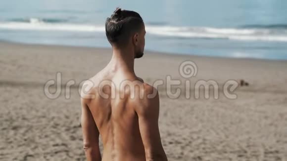 背面观看运动衫男子在海边做瑜伽视频的预览图