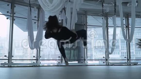 美丽的女人有着迷人的身体在吊床上做反重力空中瑜伽在吊床上做反重力瑜伽运动视频的预览图