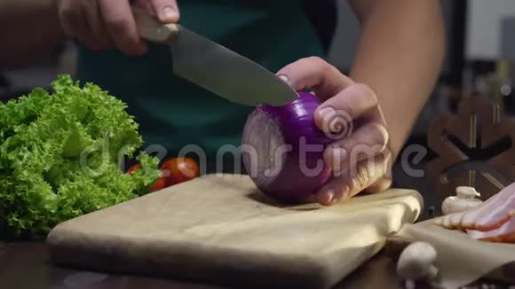 厨师在厨房的木板上用锋利的刀切下红色的洋葱并关闭烹饪蔬菜的视频视频的预览图