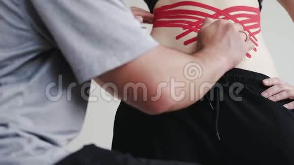 临床上治疗师将运动学磁带贴在妇女肩膀上视频的预览图