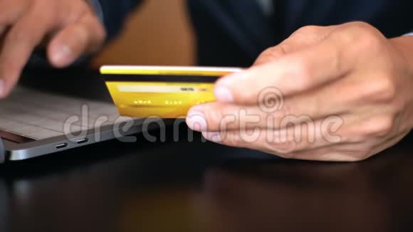 Hands持有信用卡并在家庭办公室使用笔记本电脑的4k视频支付和网上购物概念视频的预览图