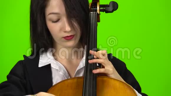 女人用手指钉大提琴绿色屏幕关门视频的预览图