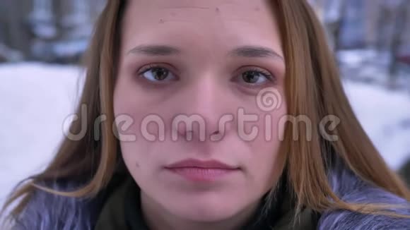 一个冬天年轻美丽的白种人女性黑发在镜头前梦幻般的特写镜头视频的预览图