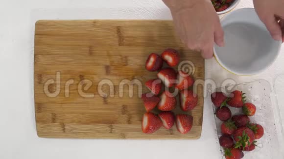 草莓在切割板上女人把浆果放在碗里从上面看水果沙拉甜点草莓果冻加工品视频的预览图