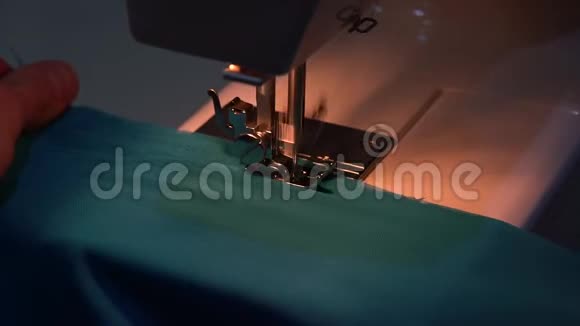 一个男人在缝纫机上缝蓝色的布料视频的预览图