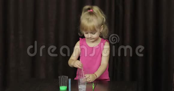 孩子们玩着做绿色黏液混合配料手做玩具的小孩视频的预览图