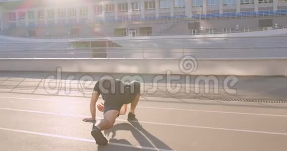 城市户外体育场上伸展的成年白种人运动男子慢跑者特写照片视频的预览图