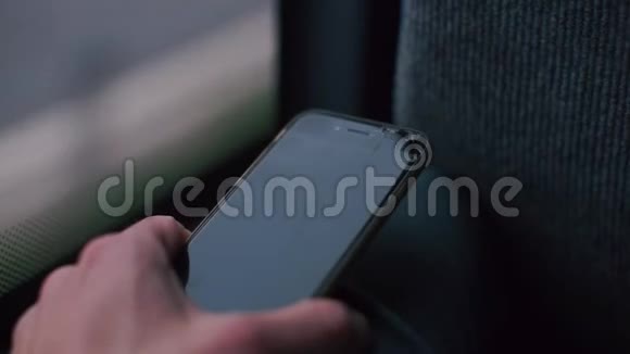 一部智能手机在公共交通巴士上的男人手中的特写视频的预览图