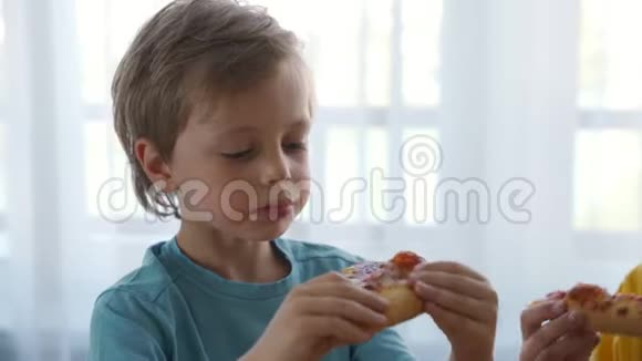 两个小白种人男孩在家吃披萨日光灯视频的预览图