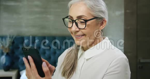 老年妇女在智能手机上发短信视频的预览图