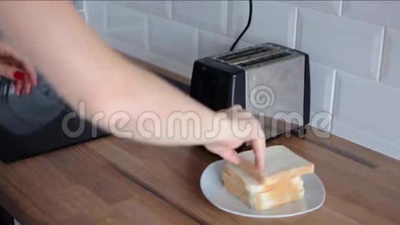 女人把面包放进烤面包机打开视频的预览图