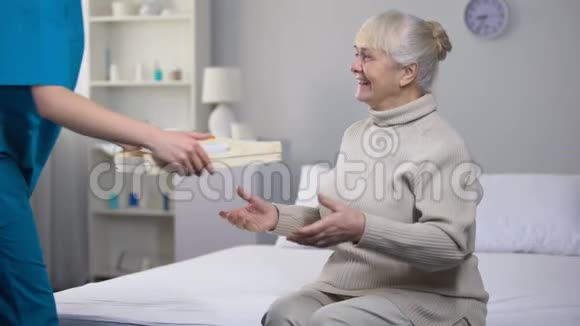 医务工作者为幸福的老太太提供晚餐良好的医院服务护理视频的预览图