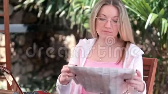 年轻的女人读报纸视频的预览图