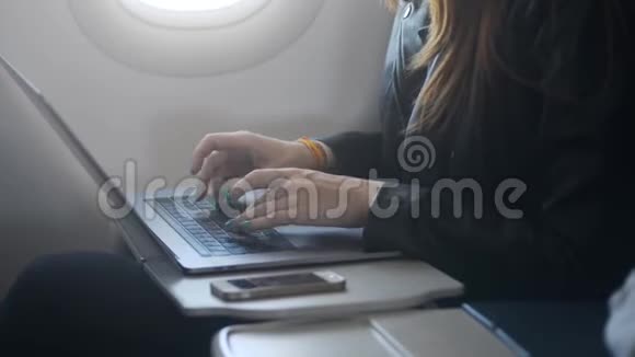 坐在飞机上使用笔记本电脑或个人电脑的女人视频的预览图