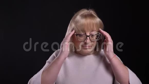 戴眼镜的高白种人金发女性的特写镜头头痛和疲劳背景被孤立视频的预览图