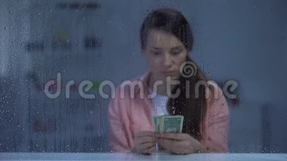 让中年妇女在雨天数钱存钱治疗感到不安视频的预览图