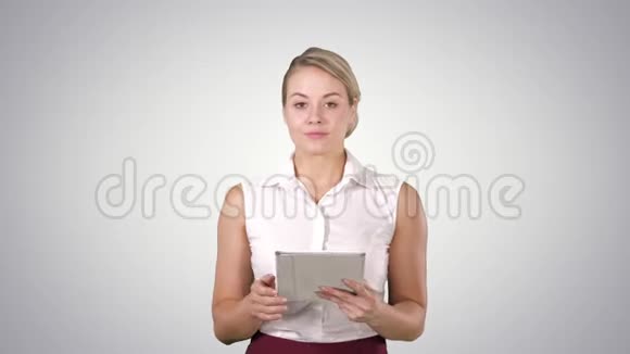 美丽的女孩拿着一个平板电脑触摸板电脑小工具在翻页看着相机阿尔法频道视频的预览图
