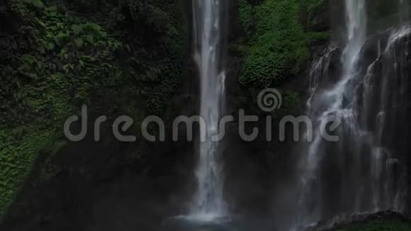 绿色雨林中的瀑布在山地丛林中鸟瞰瀑布塞库普尔有人要上去印度尼西亚巴厘视频的预览图