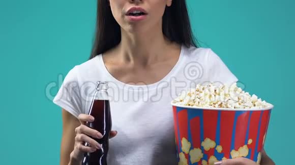 印象中的女士拿着爆米花喝着甜饮料看电影视频的预览图