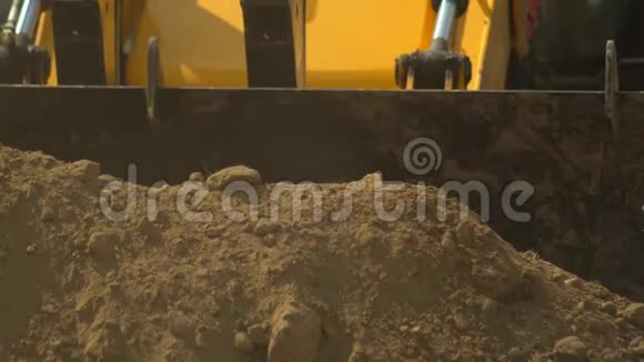 拖拉机装载机正在一个大桶中获得土壤在建设的建筑物特写建筑和道路视频的预览图