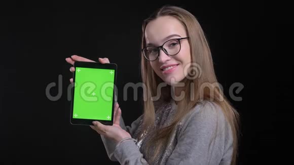 用平板电脑拍摄年轻迷人的时髦女性眼镜的特写镜头并将绿色屏幕显示到相机上视频的预览图