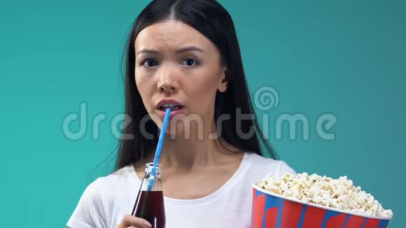 亚洲女孩带着爆米花和甜饮料看恐怖电影特写视频的预览图