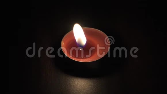 在黑暗的背景上分离出一个小的燃烧蜡烛茶盏视频的预览图