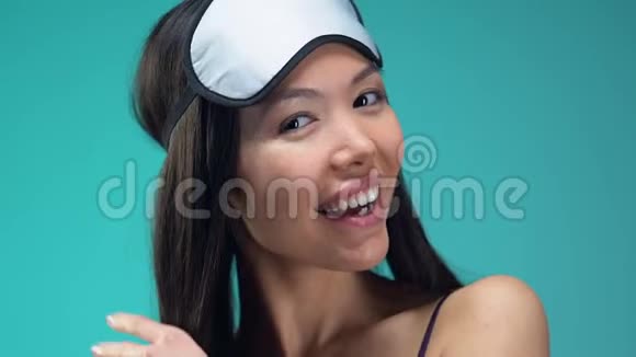 戴着眼罩的性感亚洲女士把空气吻进相机心情不错视频的预览图