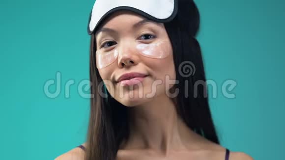 带眼罩和睡眠面罩的女人看镜头美容程序视频的预览图