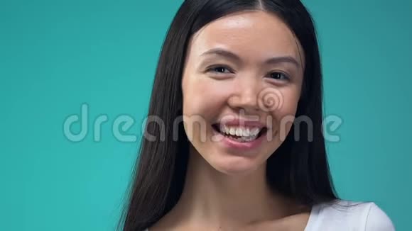 微笑的亚洲女士用心形棒棒糖闭上眼睛到处闲逛很有趣视频的预览图